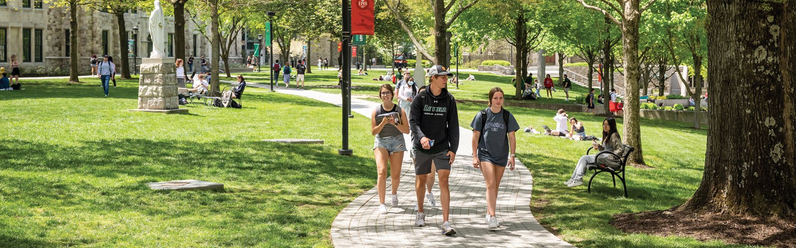 students walking outside on campus in the summer