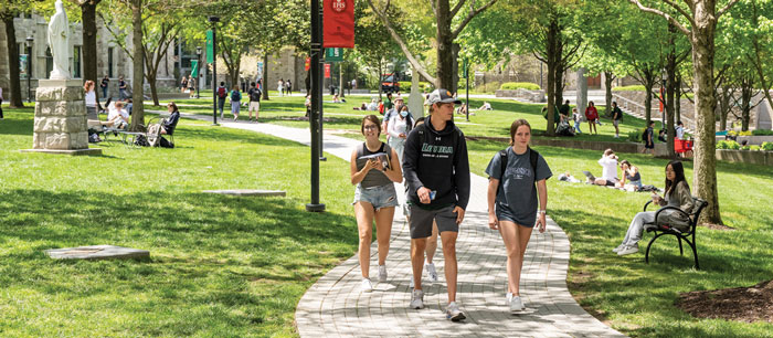 students walking on campus grounds in a summer